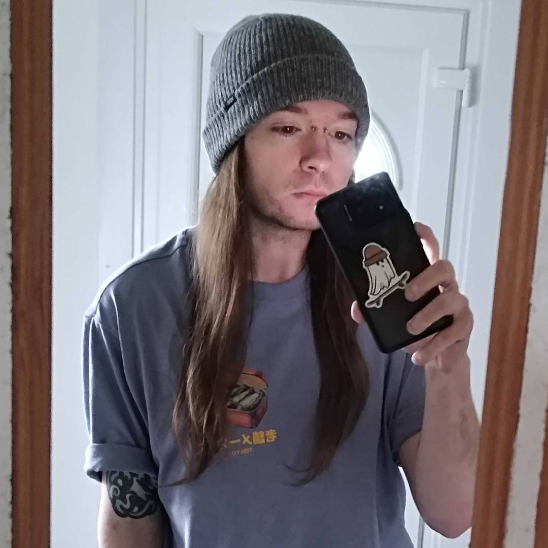 Photo of Phil Hayton in blue t shirt and grey beanie hat.