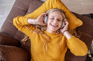 A woman relaxing happily while listening to music through her headphones.