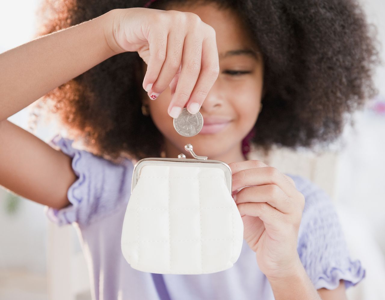 A child puts pocket money into a piggy bank