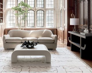A curved white boucle sofa in a classic interior