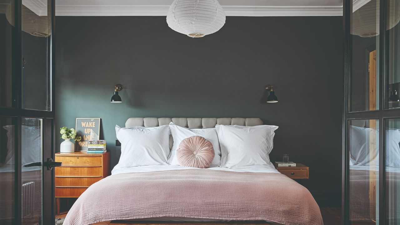 A dark painted bedroom with open glass doors leading to it