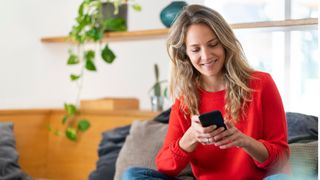 Woman texting on mobile phone at home after learning how to deal with loneliness