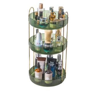 Tiered organizer with three layers in green fluted acrylic plastic with golden arched hardware. This one is stacked with perfumed and beauty products