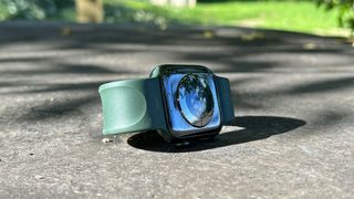 En grön Apple Watch 7 ligger på marken i ett utomhustest