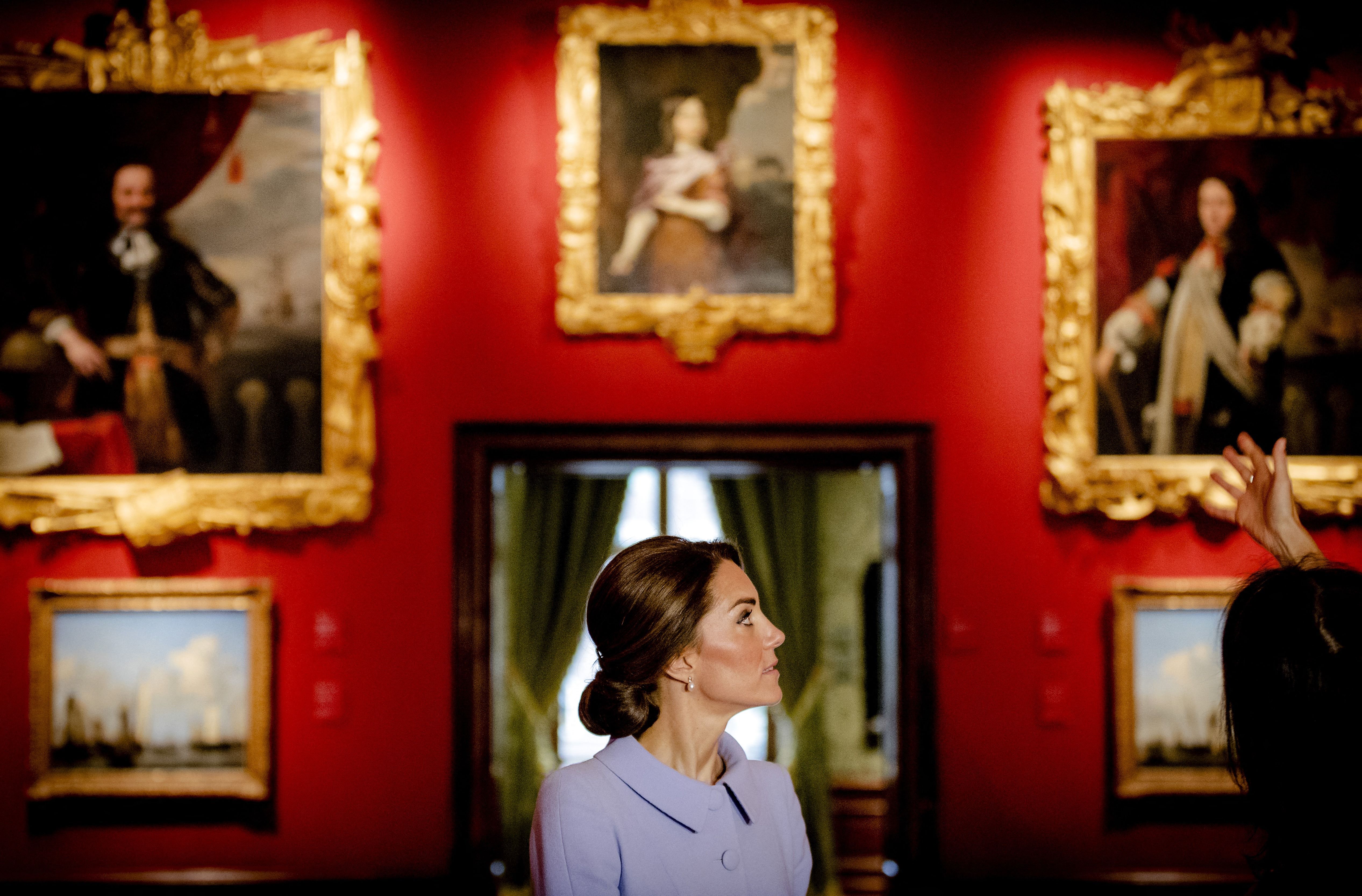 Princess of Wales standing in a red room hung with priceless works of art