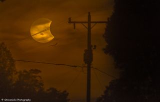 Photographer Shreenivasan Manievannan in South Carolina captured this view of the partial solar eclipse of Oct. 23, 2014 through fog and power lines, revealing an ethereal view of the event and giant sunspots on the sun.