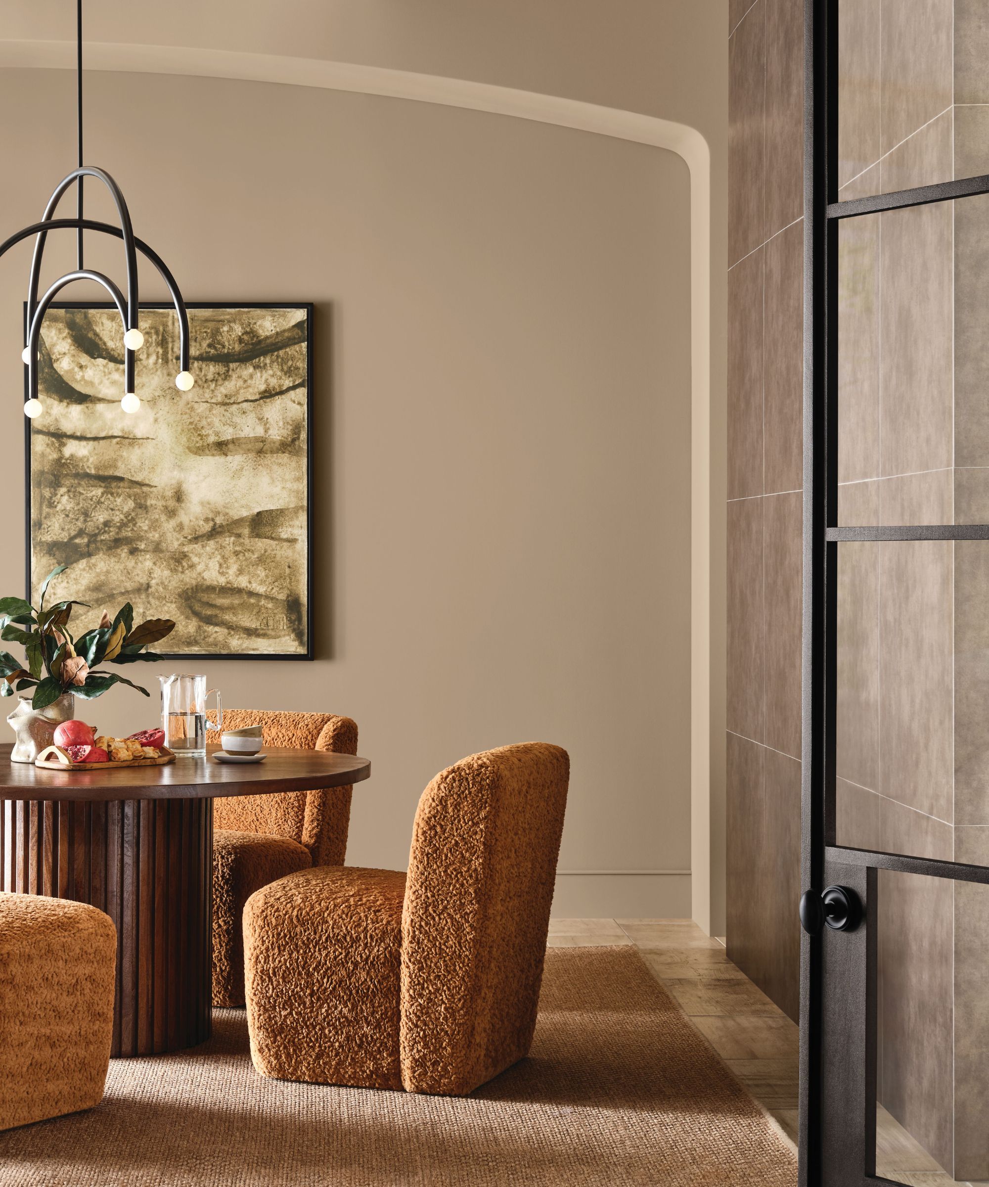 Dining room with neutral walls, crittall door, wood dining table, boucle chairs and pendant light