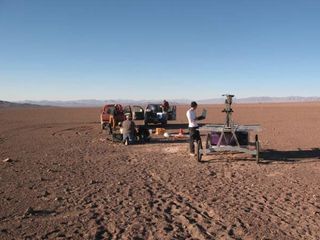 The Zoë rover being checked out at the start of its Atacama Desert traverse in June 2013. In the background are the two 4x4 trucks that were used to follow the robot. The engineers stay within communication range to monitor the robot but try to say out of view as much as possible.