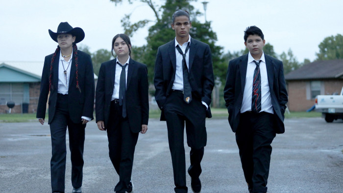 Cast of Reservation Dogs walking in suits