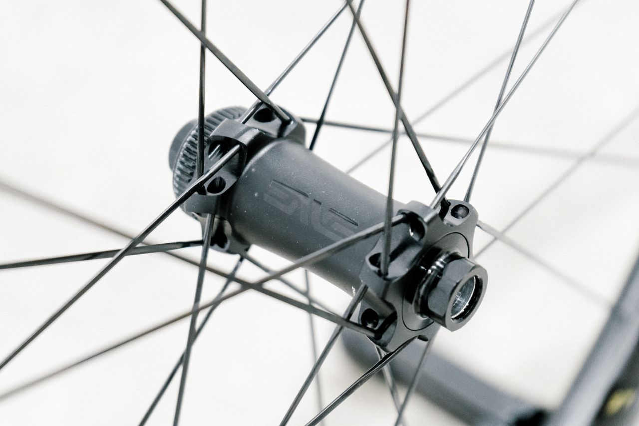 An aero road wheel stands against a white wall