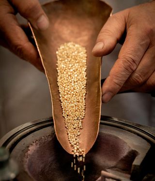 Gold beads being poured into a machine