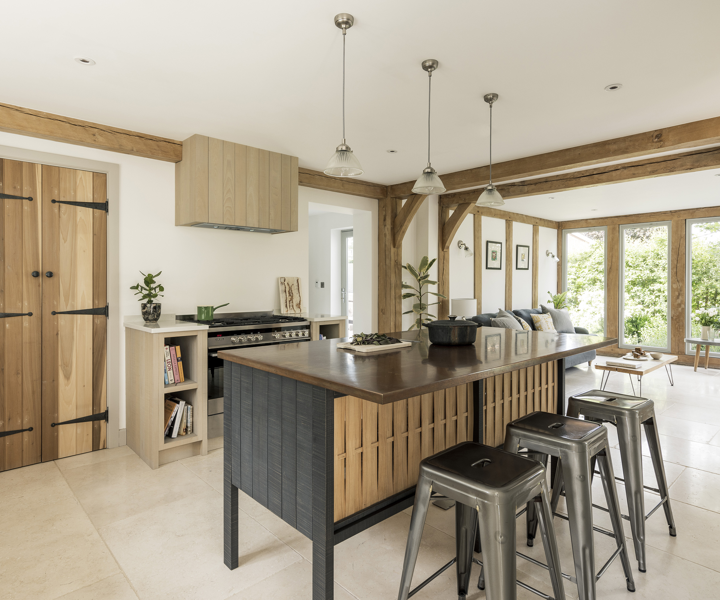 A modern but rustic kitchen with wooden cabinets and light tiled floor. There is a free standing kitchen island