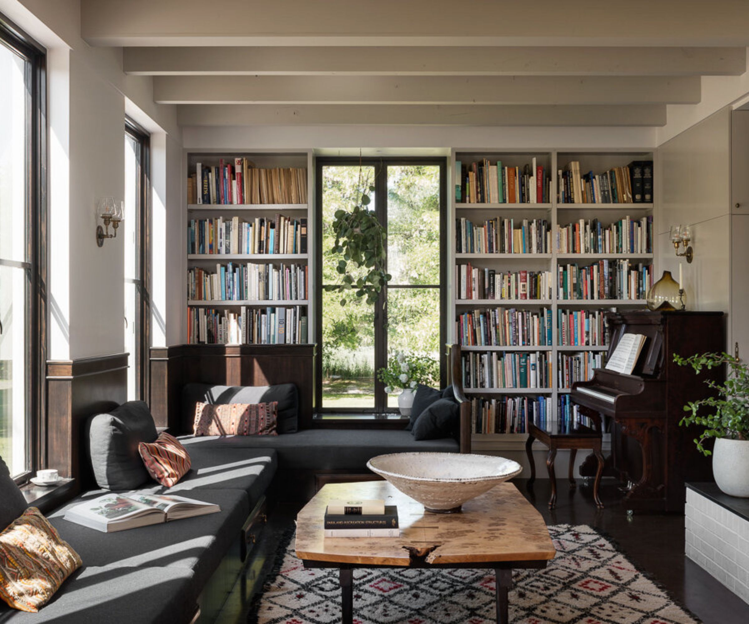 Living room with beams, built-in bookshelves, sofa and piano