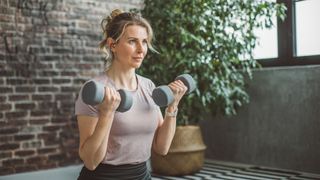 Woman using weights to bicep curl