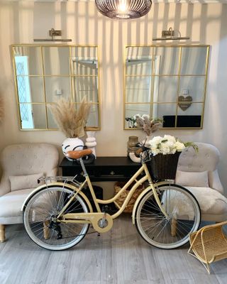 Greige hallway with black console, natural accents and mirrors with gilded edge