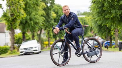 Sir Chris Hoy sits on road bike fitted with the Skarper DiskDrive e-bike system