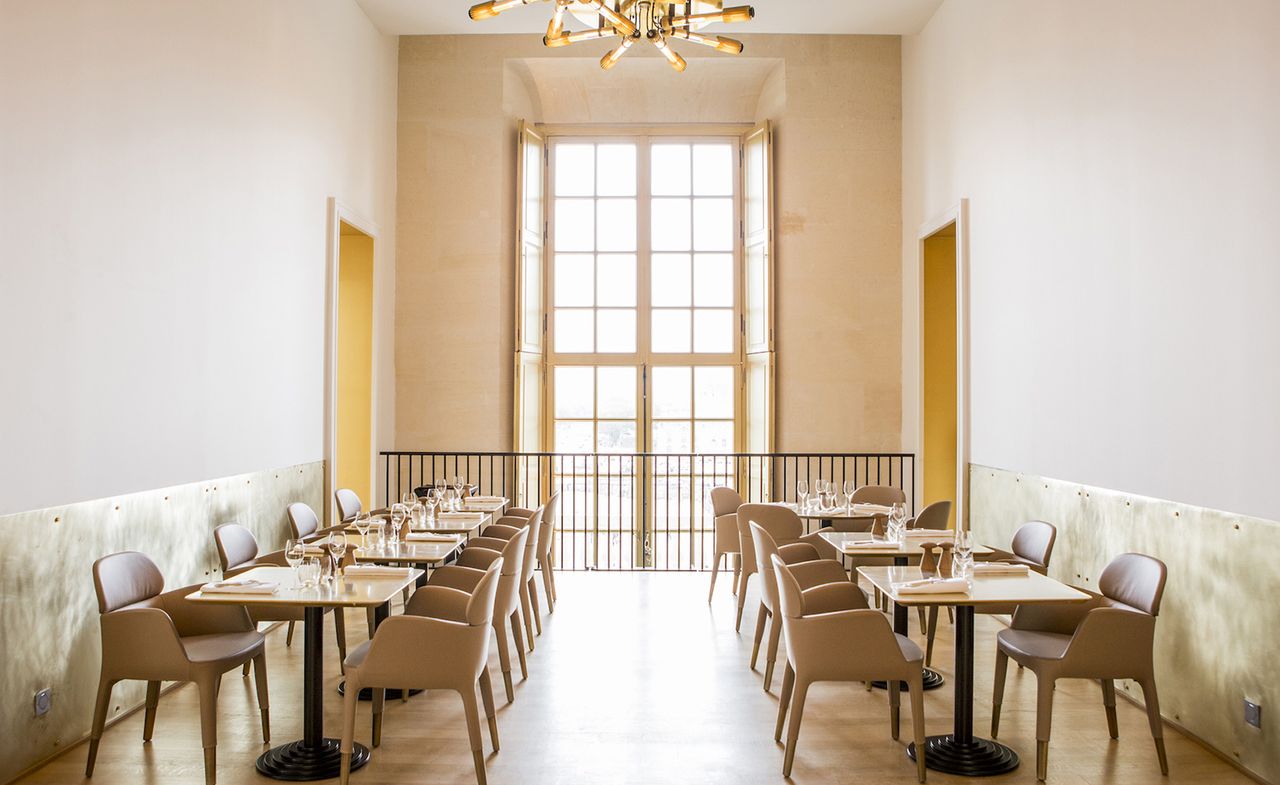 Light cream chairs with matching square tables in rows on balcony