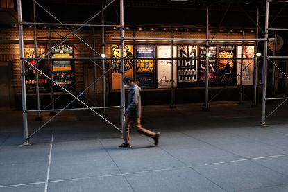 People walk through the empty Broadway theater district one year after it was closed due to Covid-19 restrictions on March 12, 2021 in New York City.