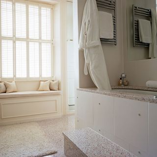 bathroom with pale stone tiles and bathtub