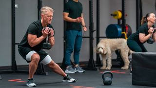 Man performing side lunge holding dumbbell