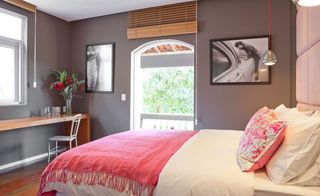 Club House Rio bedroom with hanging light and pink pillows