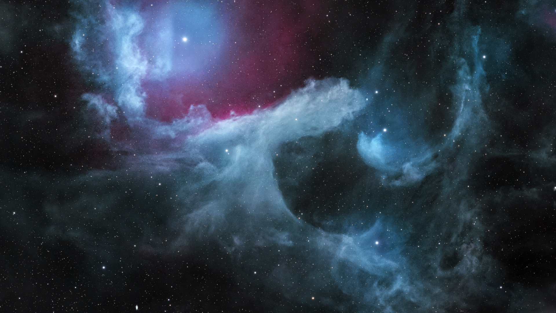 Nebula clouds are pictured shining with the cold light of nearby stars. Sweeping cloud patterns and cavities are visible.