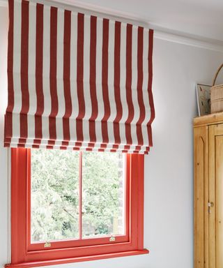 window with red frame, red and white striped blind, wardrobe to right