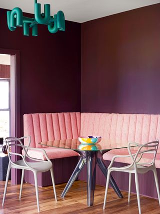pink banquette in brown dining room