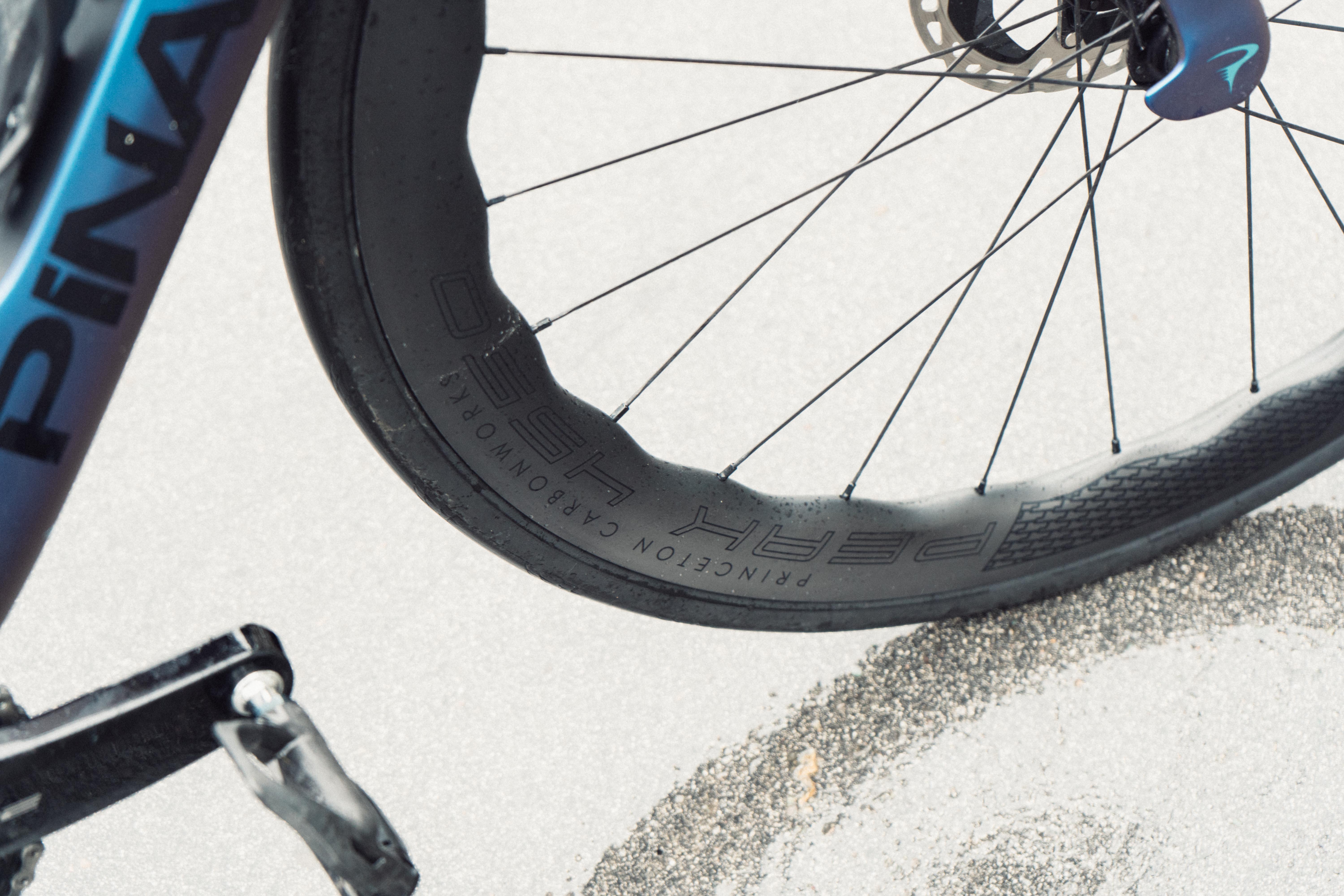 A close up of the black rim of a blue racing bike