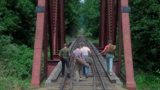 The kids of Stand By Me walk on train tracks