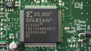 A computer chip manufactured by Xilinx, as seen placed on a circuit board