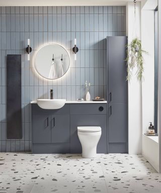 blue tiled bathroom with white sanitary wear and inset sink