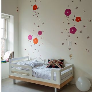 childs summer bedroom with pink flower sticks on walls