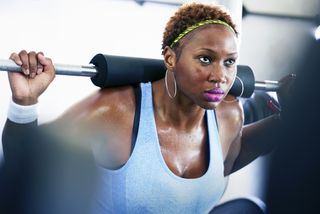 getting over a breakup - woman lifting weights at the gym