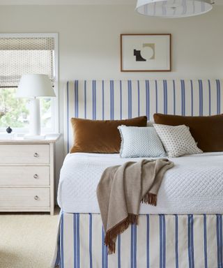 blue and white coastal bedroom with toffee velvet cushions and modern decor