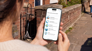 Person holding phone showing Ring Neighbours app