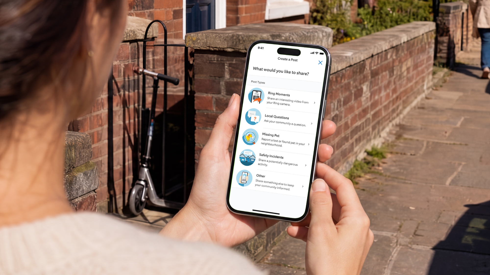 Person holding phone showing Ring Neighbours app