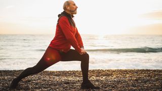What are the benefits of lunges? Image shows man lunging on a beach