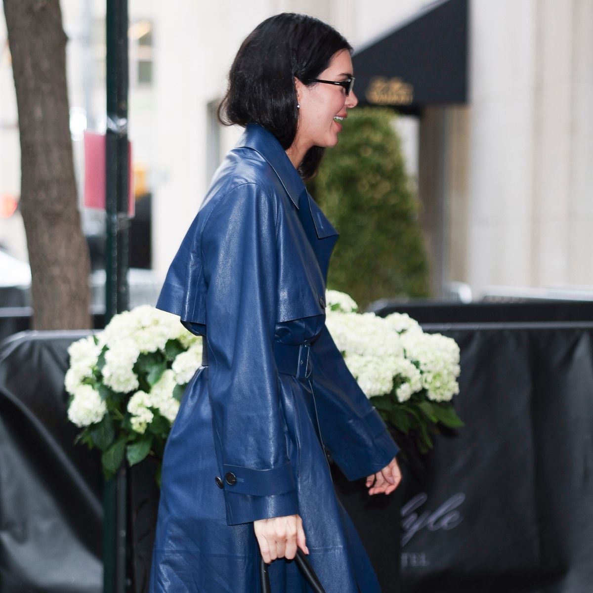 Kendall Jenner wears a blue leather trench coat, carries The Row Marlo bag