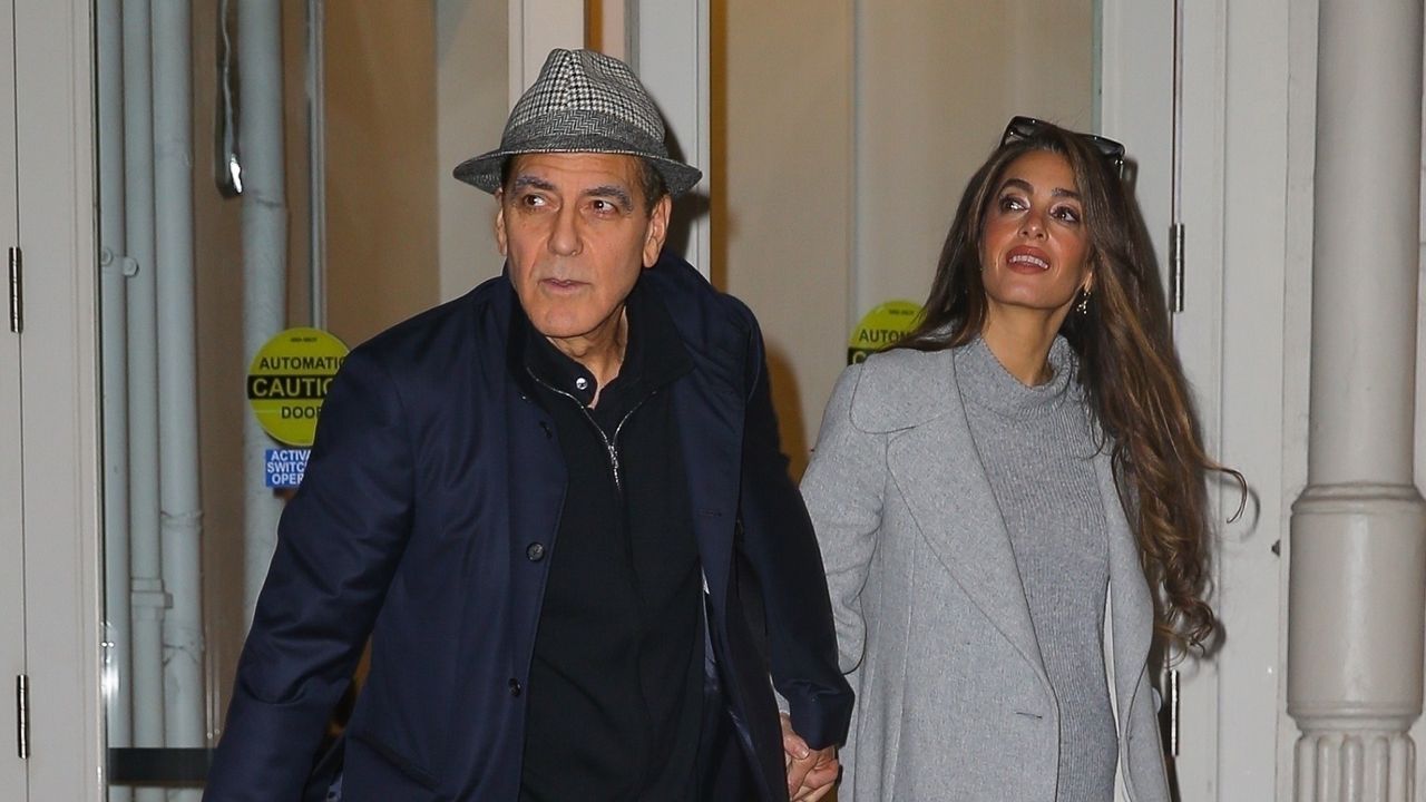 George and Amal Clooney walking together in New York City where Amal wears an outfit similar to Taylor Swift&#039;s favorite date night outfit formula: a sweater and thigh high boots