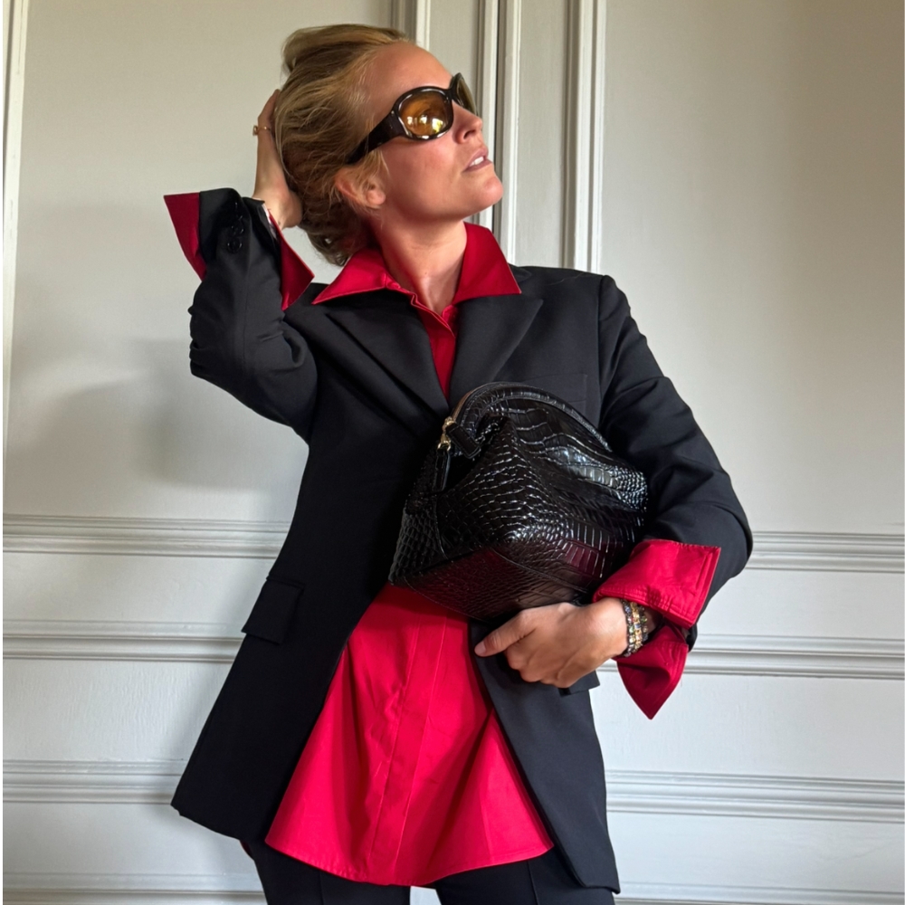 blanca miro wears a black suit and red shirt as a transitional autumn outfit