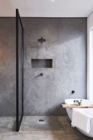 A black bathroom idea with matt black shower head and concrete grey walls