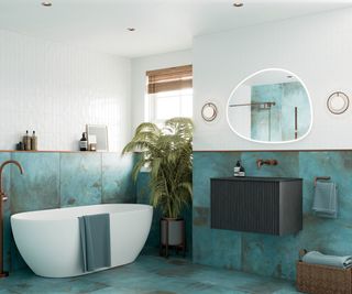 bathroom with large turquoise tiles on floor and half of wall, white freestanding bath, black wall mounted vanity unit, ceiling spotlights and lights either side of mirror above sink