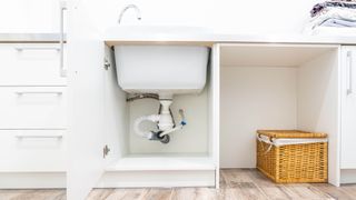 An empty cabinet underneath the kitchen sink