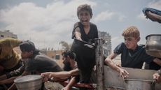 A child extends his pot amid food shortages in Gaza