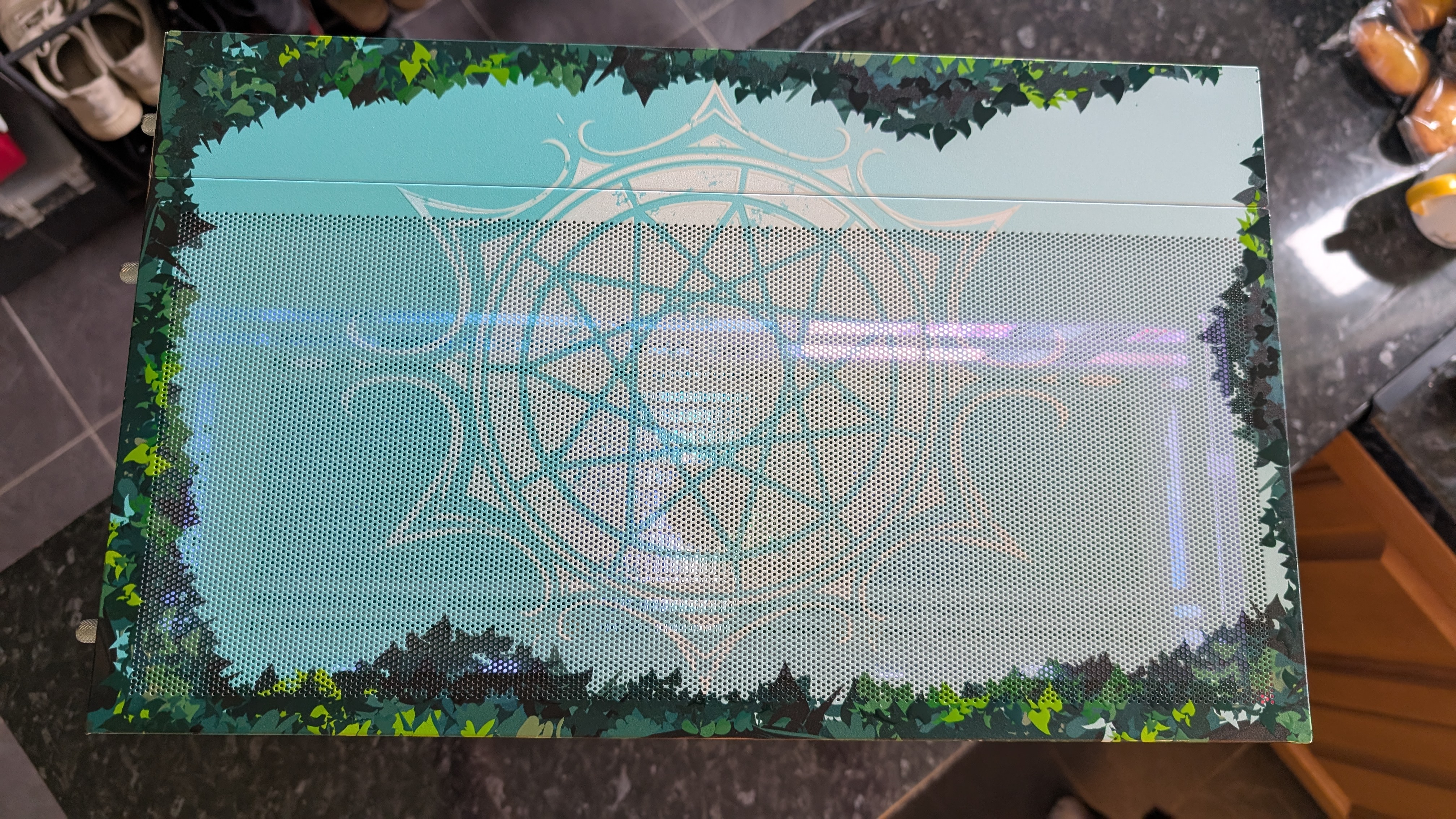 The Starforge Systems Frieren PC, photographed on a dark worktop with the RGB lighting switched on.