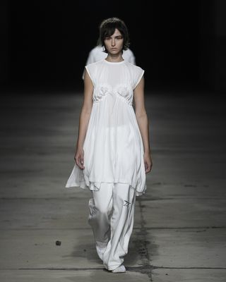 Model with white outfit walking on runway at the Milan Fashion Week