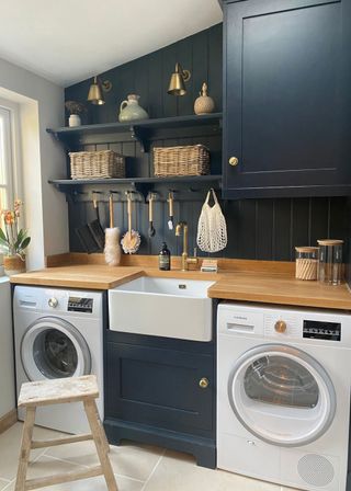 Small laundry room ideas with midnight blue painted cabinetry and wooden backsplash, open shelving and wooden worktop.