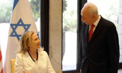 Secretary of State Hillary Clinton signs a book Monday during her Jerusalem meeting with Israeli President Shimon Peres.