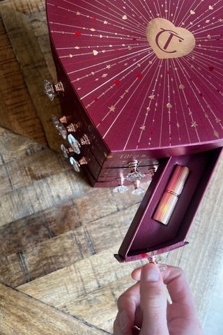 Katie Thomas opening up a drawer from the charlotte tilbury beauty advent calendar to reveal a matte revolution lipstick